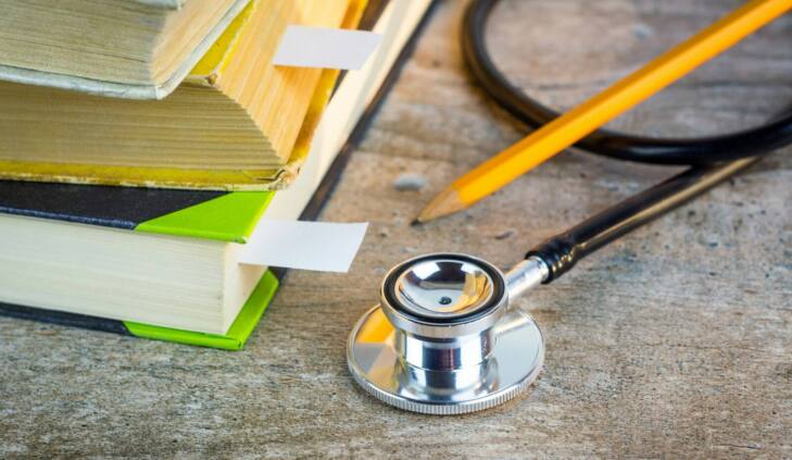 a stethoscope sitting on top of a pile of books
